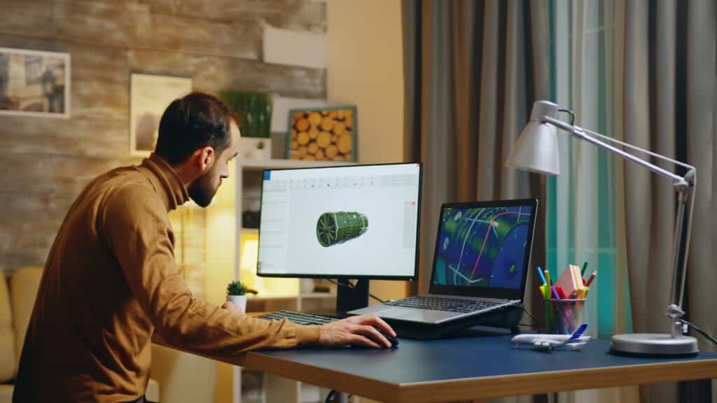 Young engineer using AI design tools in his home office to develop a new turbine software interface.